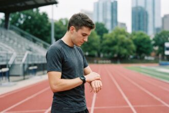 Jeune athlète vérifiant ses statistiques sur une smartwatch